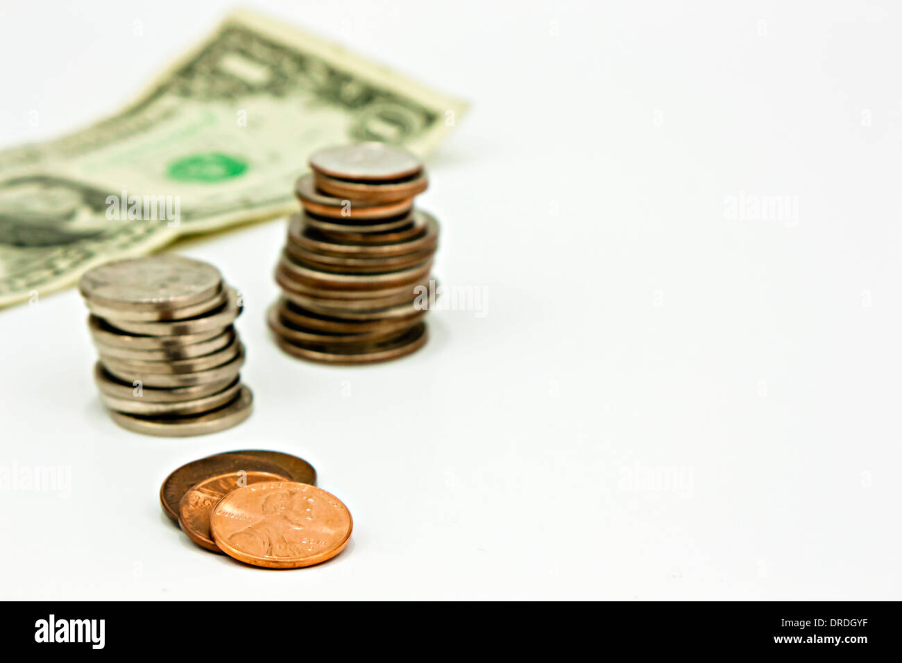 Money stacked on white, nickels, dimes, quarters, pennies, dollar bill. US currency. Stock Photo