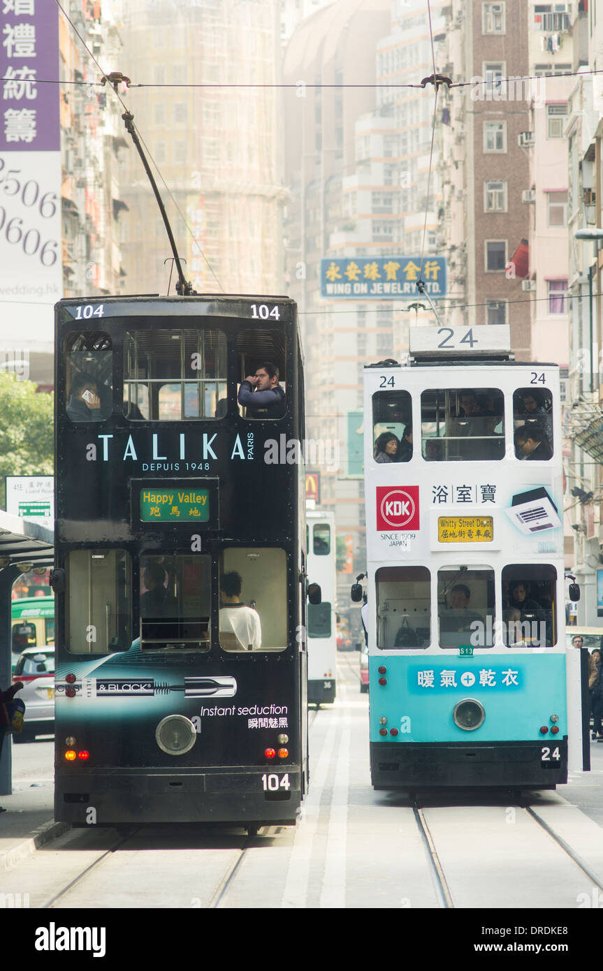 Tram passing each in Hong Kong street, with populated street Stock Photo