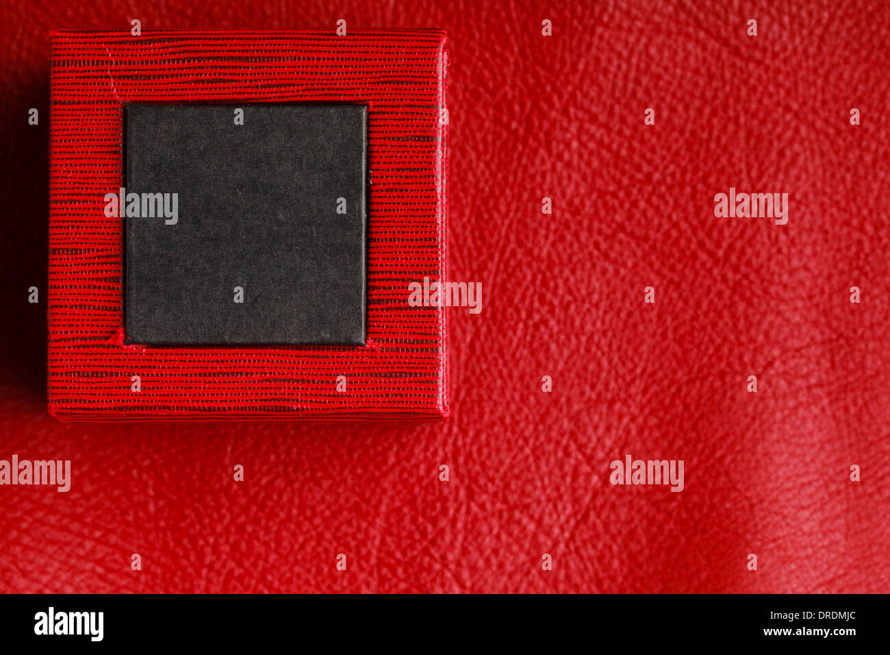 Red black rectangular ring jewellery box on leather background Stock Photo