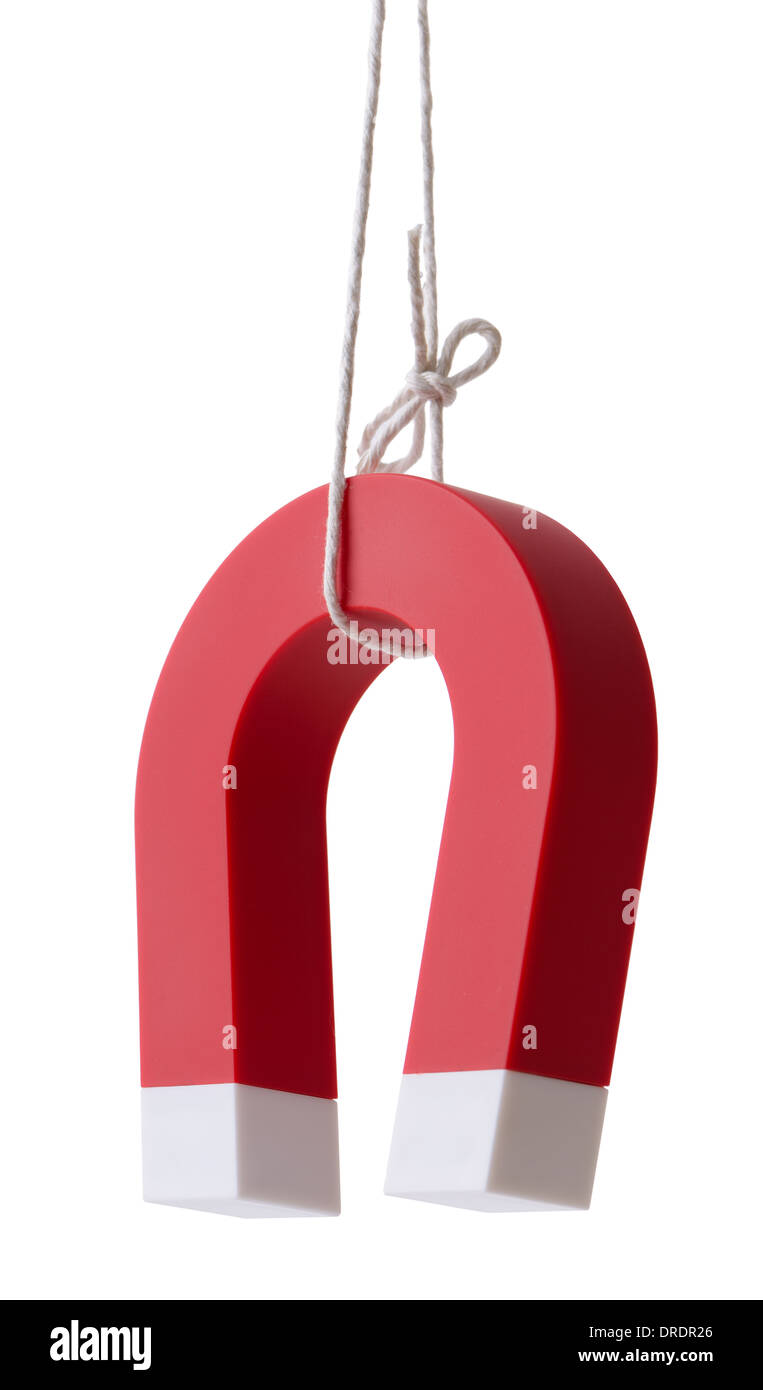 A horse shoe magnet dangling on string isolated on a white background with clipping path Stock Photo