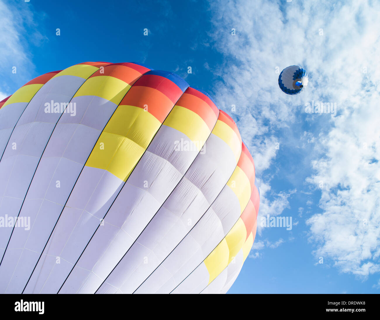 Multicolored Balloon in the blue cloudy sky Stock Photo - Alamy