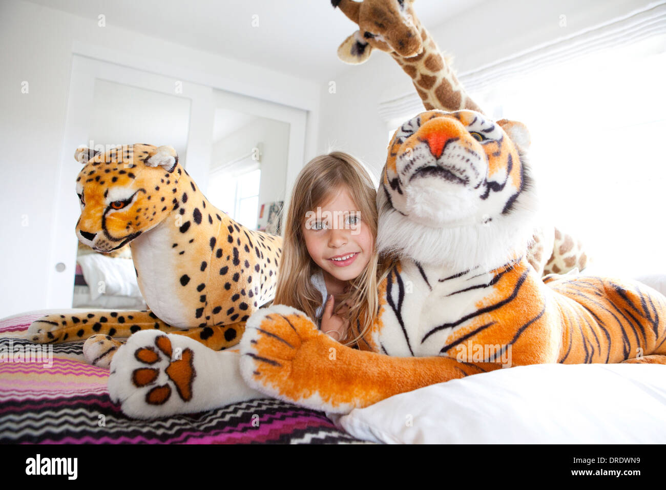Young girl laying with stuffed animals Stock Photo - Alamy