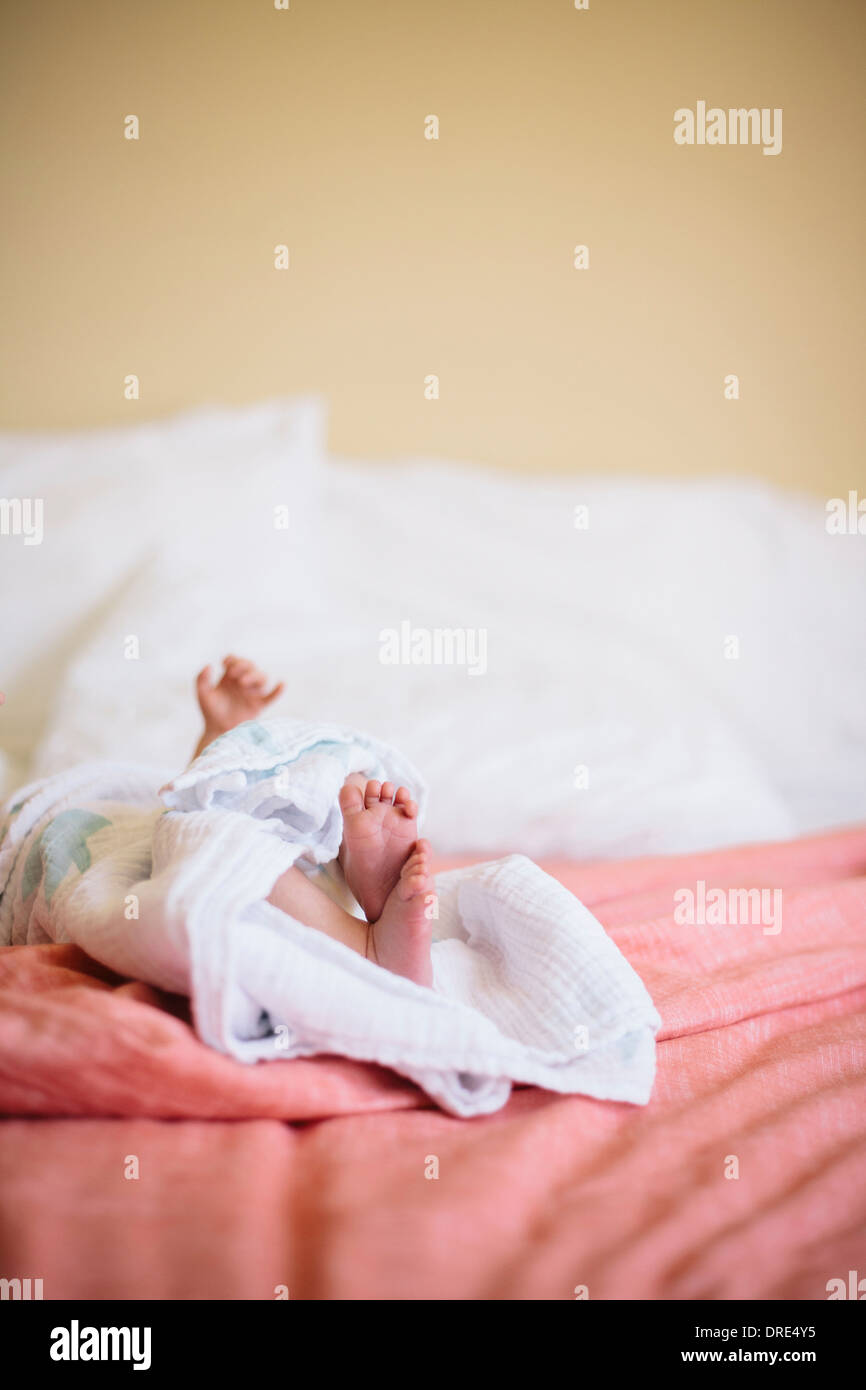 Small baby laying on bed Stock Photo