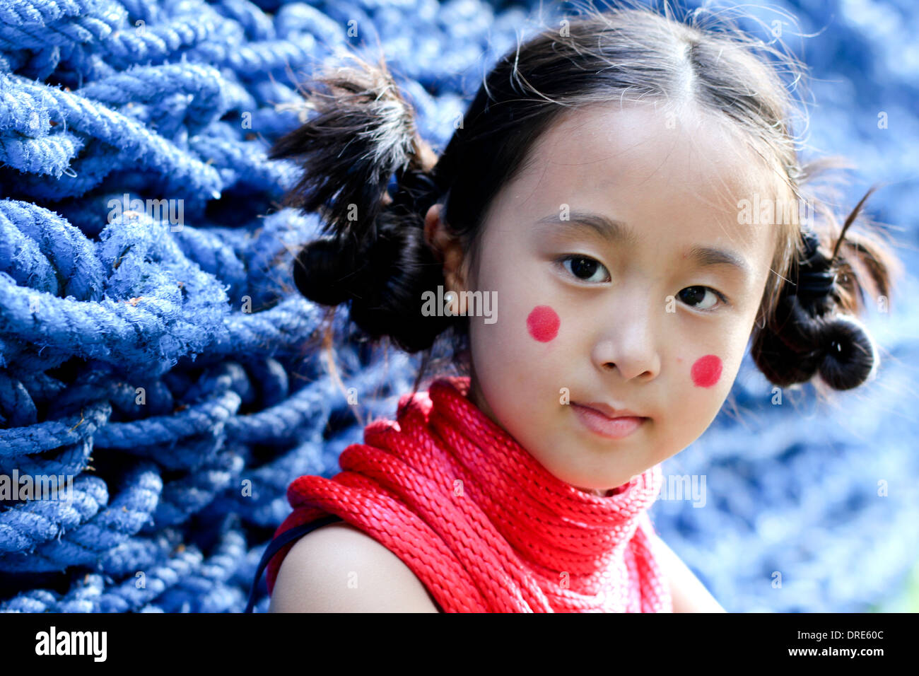 Asian girl in front of blue rope wall Stock Photo