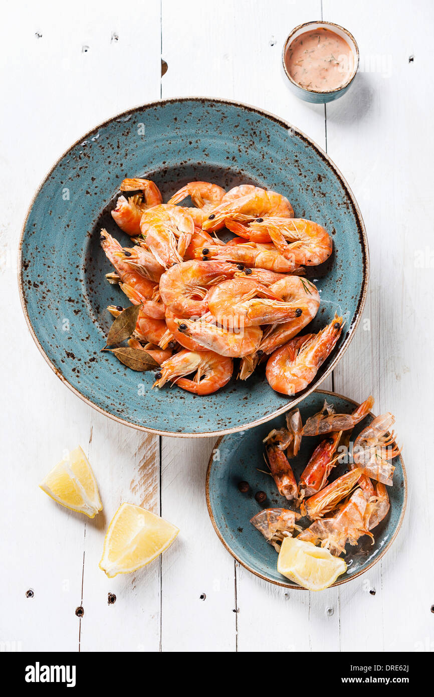 Prepared shrimps on blue plate on wooden background Stock Photo