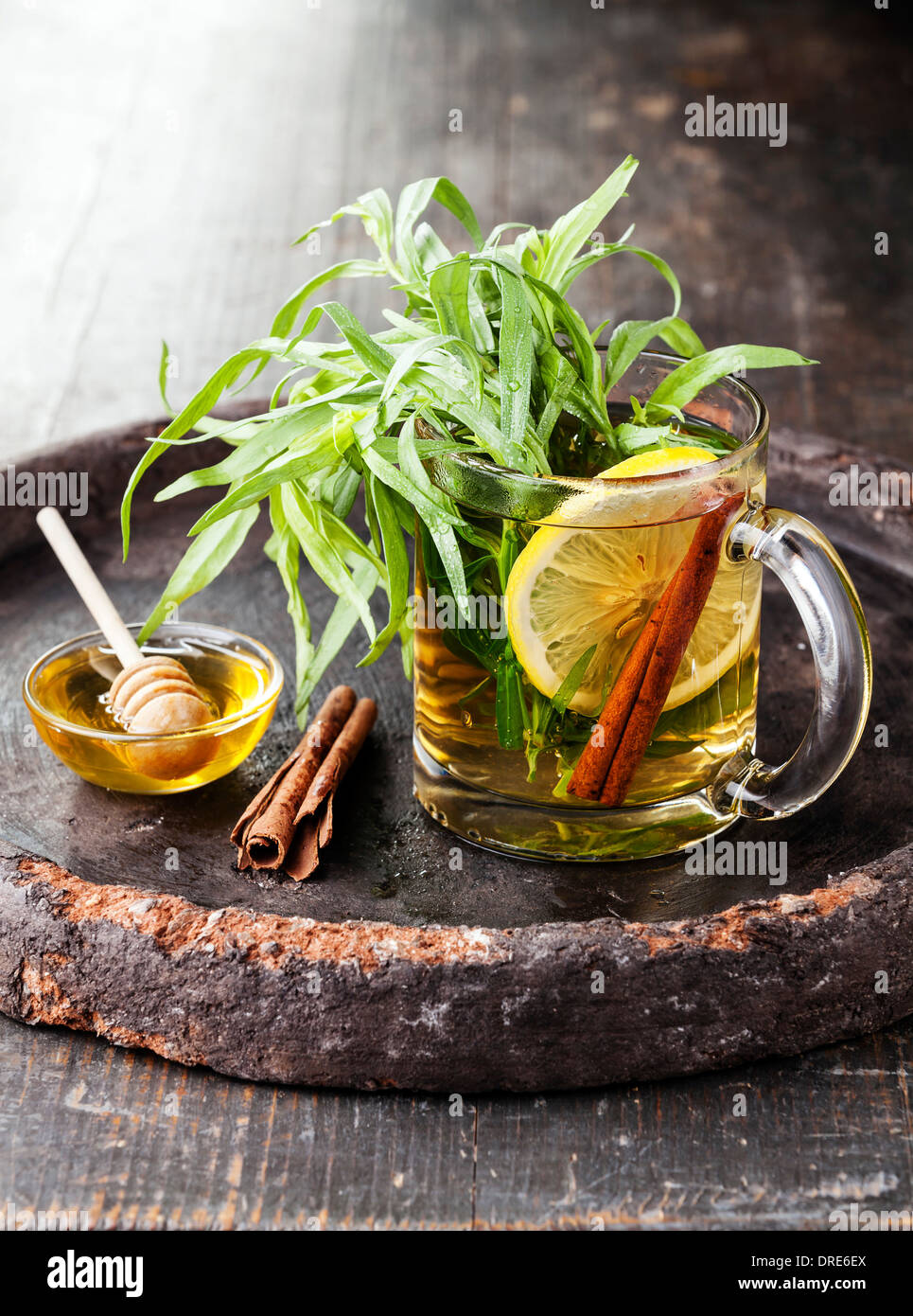 Tarragon hot drink tea with honey, lemon and cinnamon on dark background Stock Photo