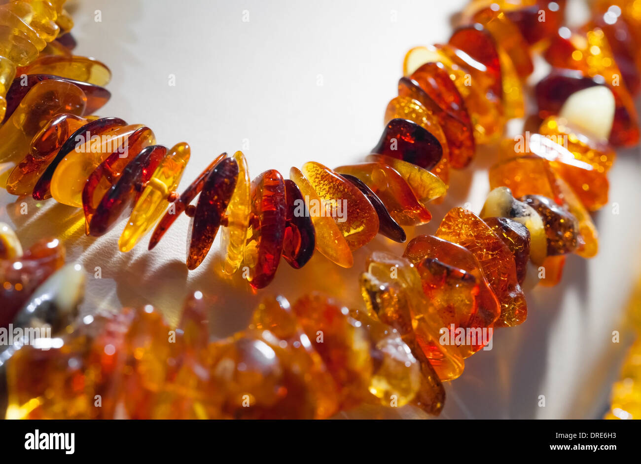 Macro photo of orange amber beads on white background Stock Photo