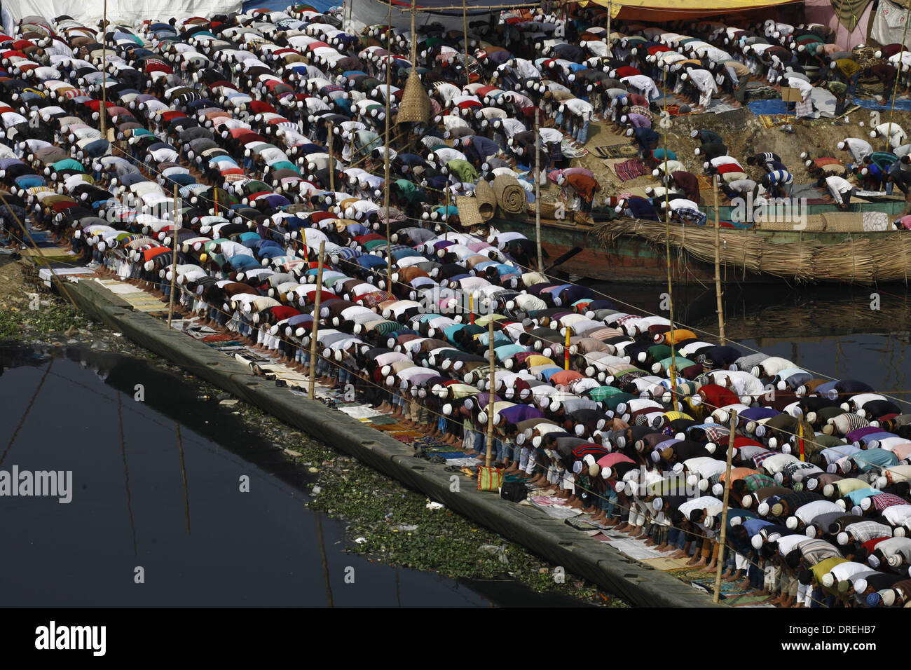 Dhaka, Bangladesh 24th January 2014;Thousands of Muslims attend the Jumma prayer on the banks of the river Turag during the first day of the three-day long Muslim Congregation. At least two million devotees from home and abroad have gathered at the prayer ground to participate. The first phase of Ijtema is ready to start, as those who come to Bangladesh for Ijtema, the second largest Muslim congregation after the Hajj, are greeted with ready facilities for their pilgrimage to the Turag river bank. Credit:  zakir hossain chowdhury zakir/Alamy Live News Stock Photo