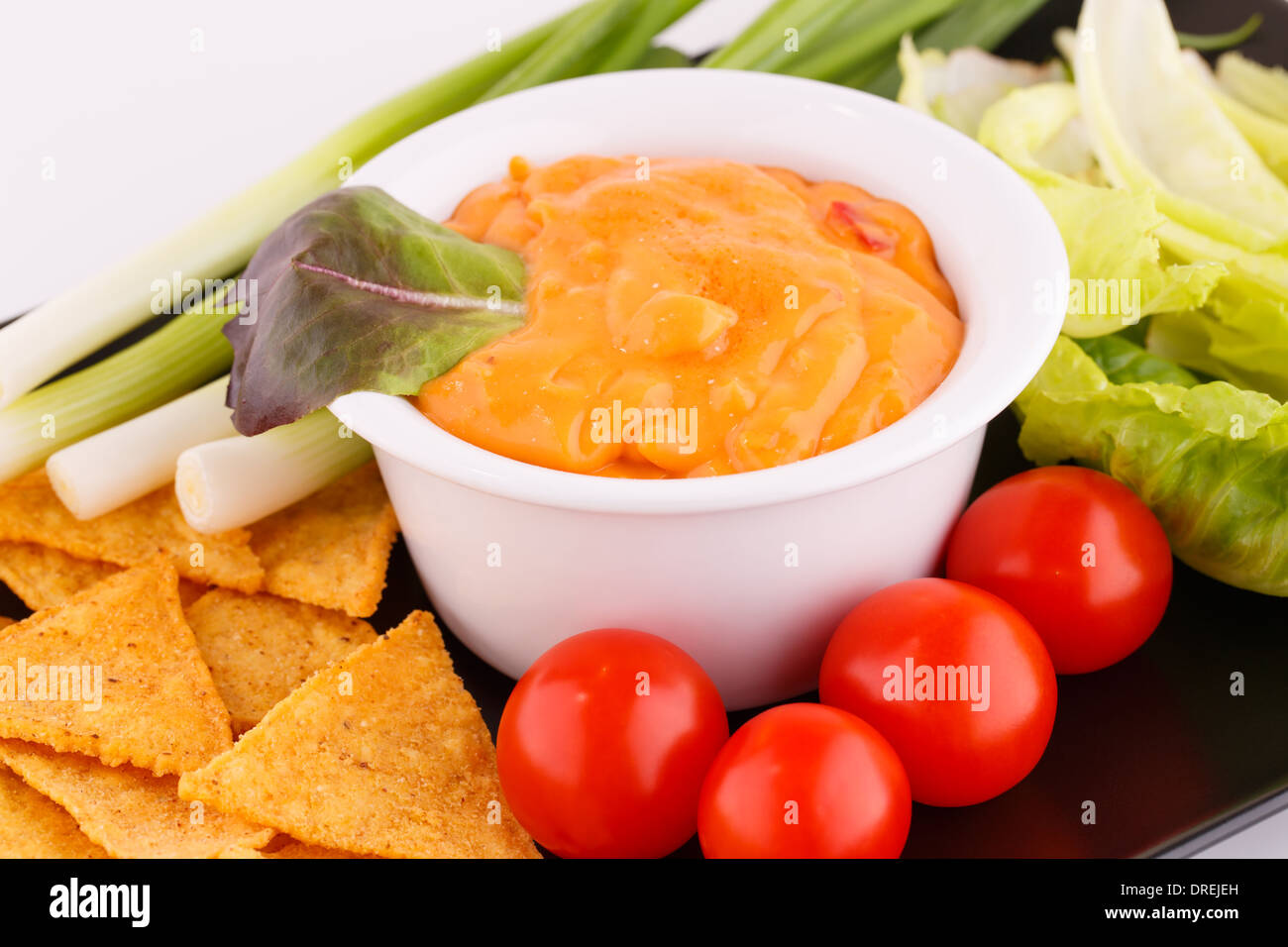 Nachos, cheese sauce, vegetables image Stock Photo Alamy