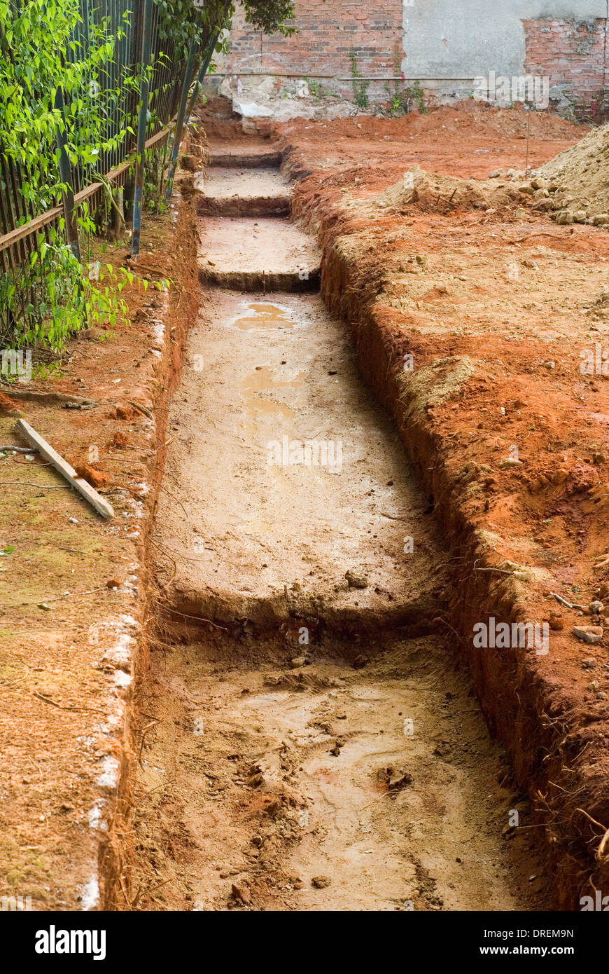 Digging a trench foundation for constructing a high boundary wall for home property. Stock Photo
