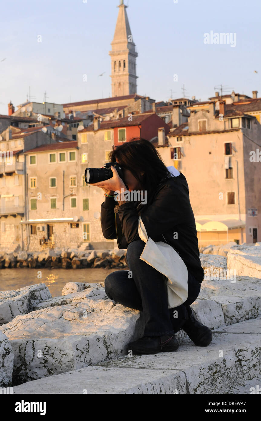 Woman Photographer photographing a travel landscape in Rovinj Croatia Stock Photo