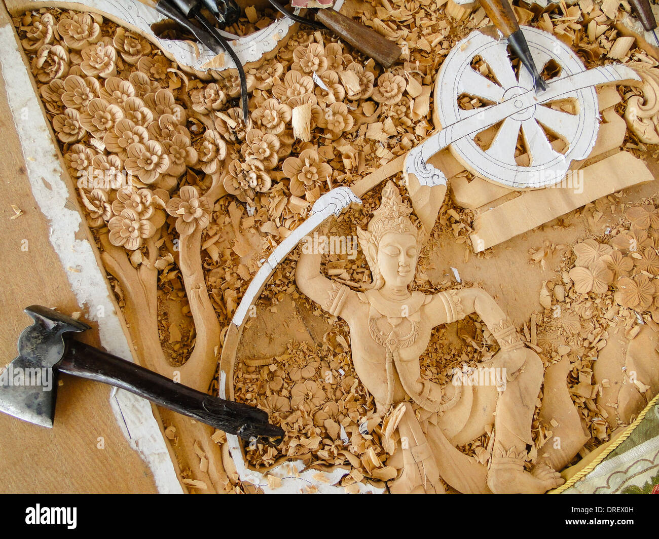 skillful engravements. carving tools are lying on the panel. hand made for a temple in Thailand. Stock Photo
