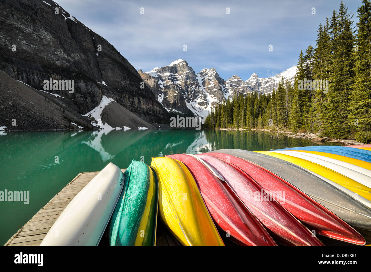 Coloured canoes at lakeside Stock Photo