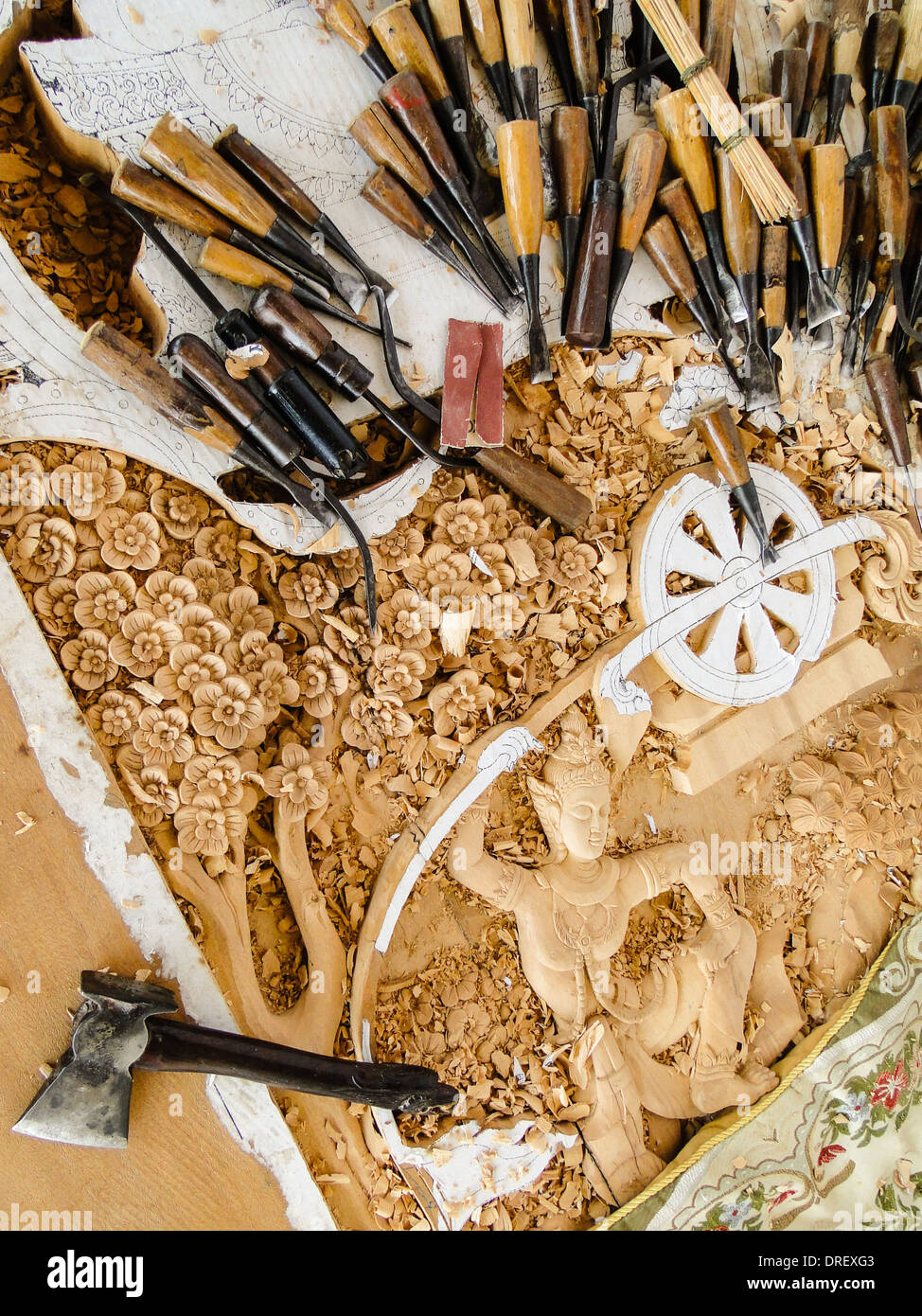 skillful engravements. carving tools are lying on the panel. hand made for a temple in Thailand. Stock Photo