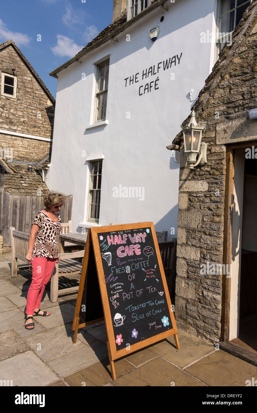 A woman looking at handwritten menu on blackboard by The Halfway Cafe on Minchinhampton Common, Gloucestershire, UK Stock Photo