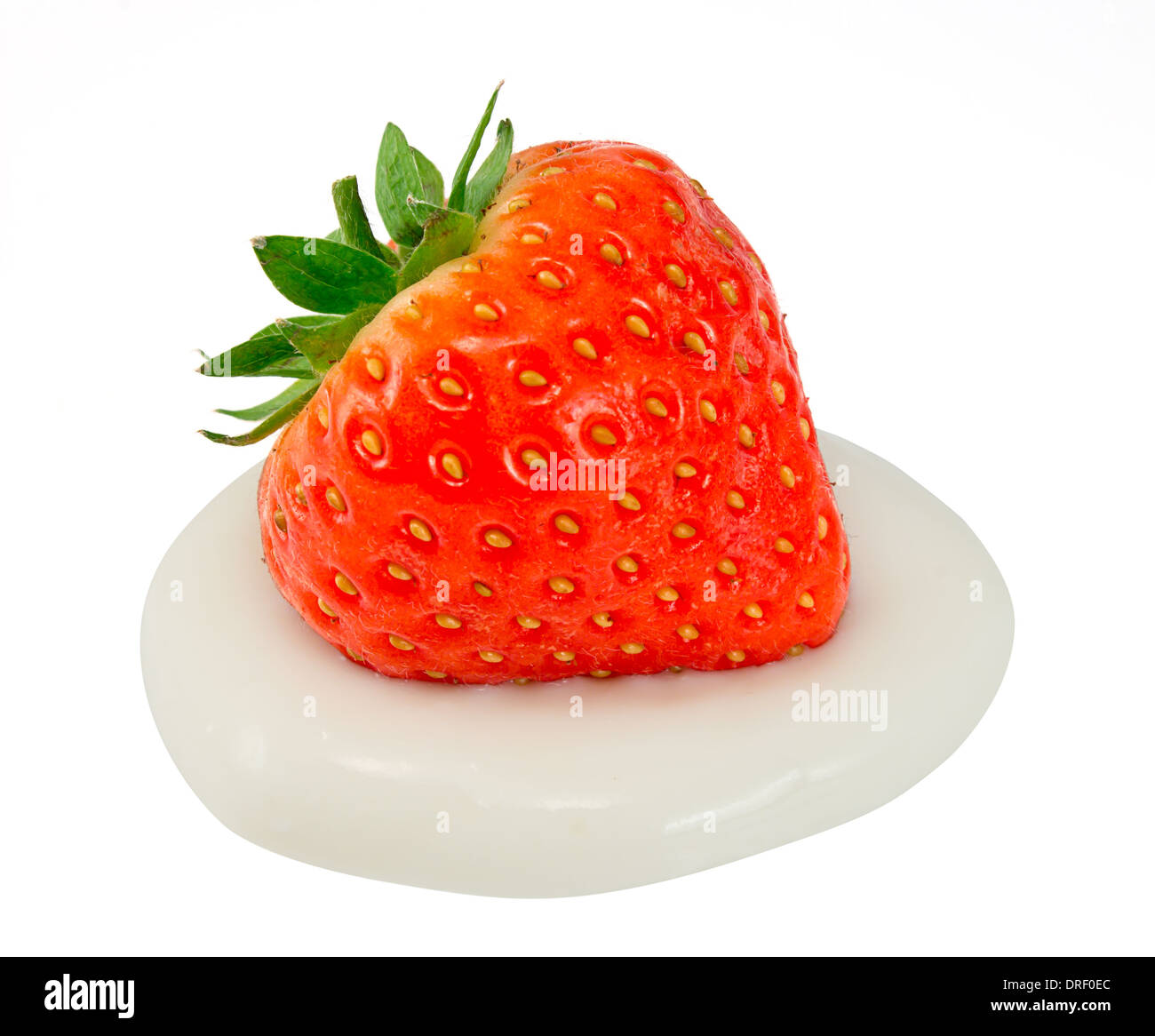 Strawberry on a dollop of fresh cream isolated against a white background Stock Photo