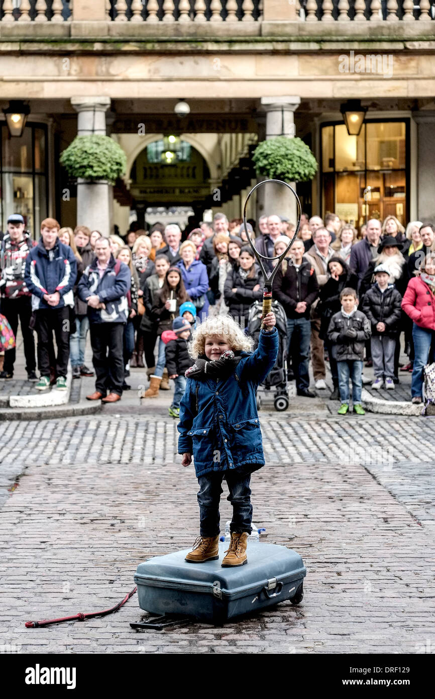 A young boy performing in a street entertainers act in Covent garden Piazza. Stock Photo