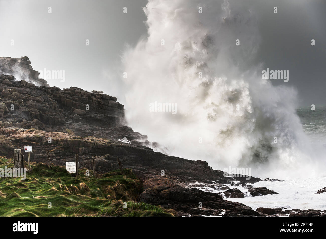 Large waves crash into rocks at Sennen Cove in Cornwall. Stock Photo