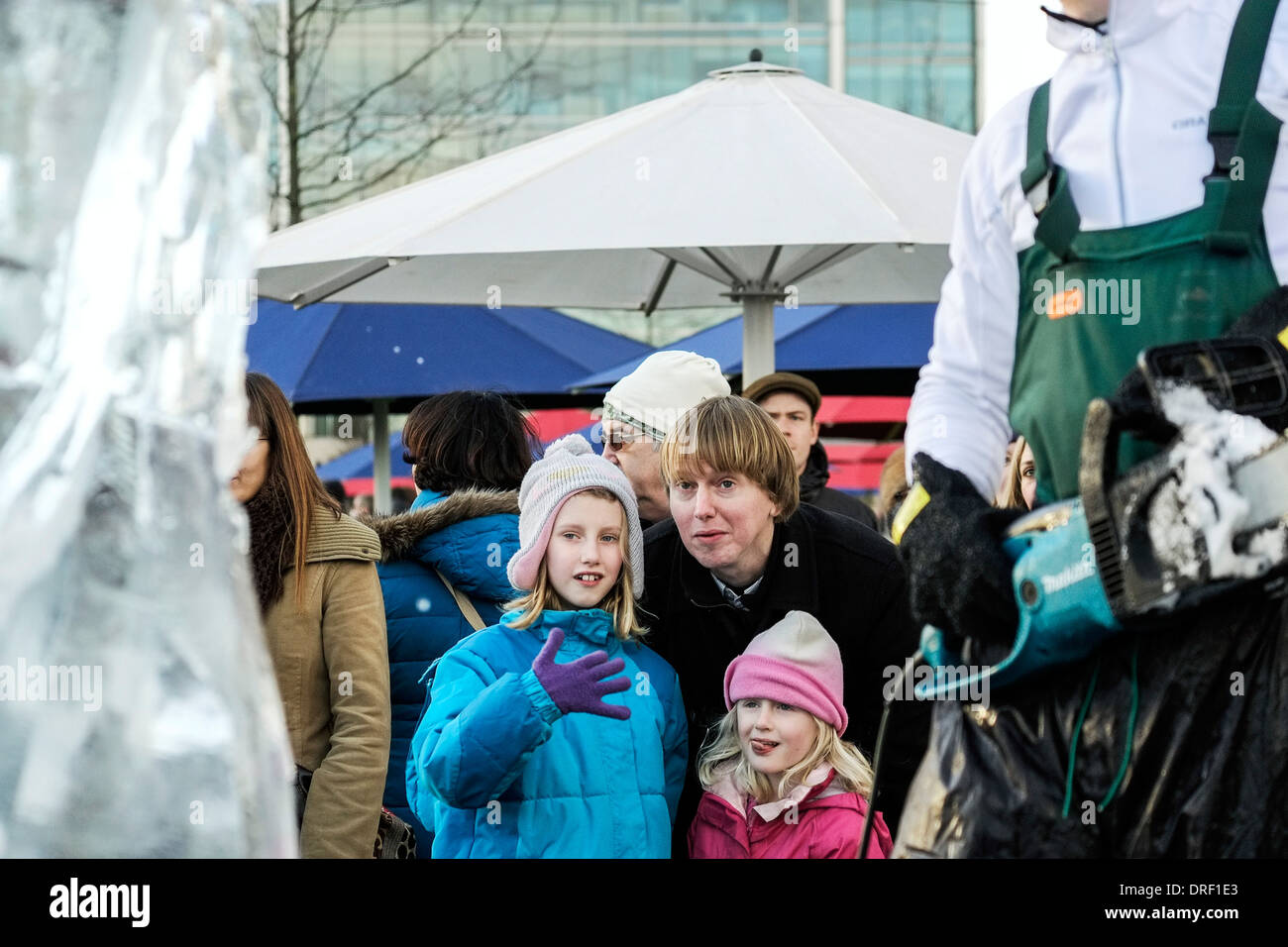 Children look on as an artist works to create a sculpture as part of the London Ice Sculpture Festival 2014 Stock Photo