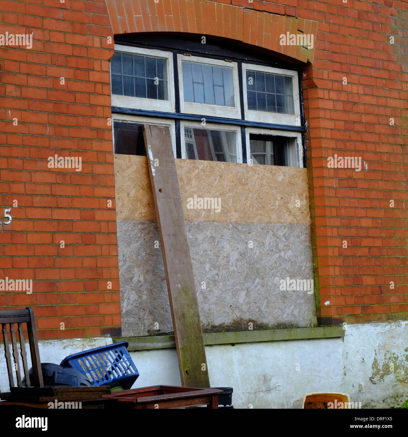 Boarded up window on derelict abandoned property in Luton Stock Photo