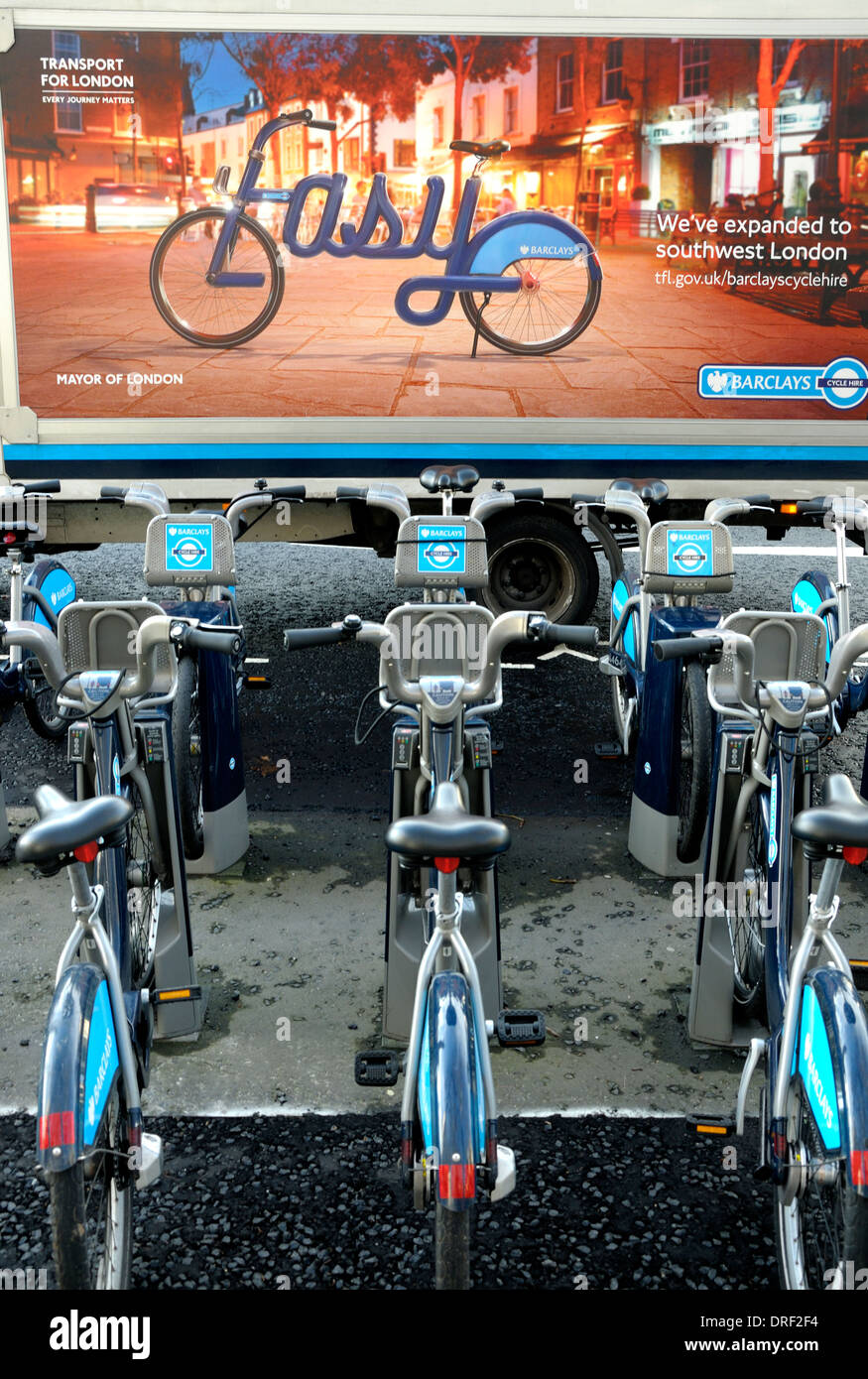 London, England, UK. Boris Bikes / Cycles for Hire, in front of a Transport for London van with advertising poster Stock Photo