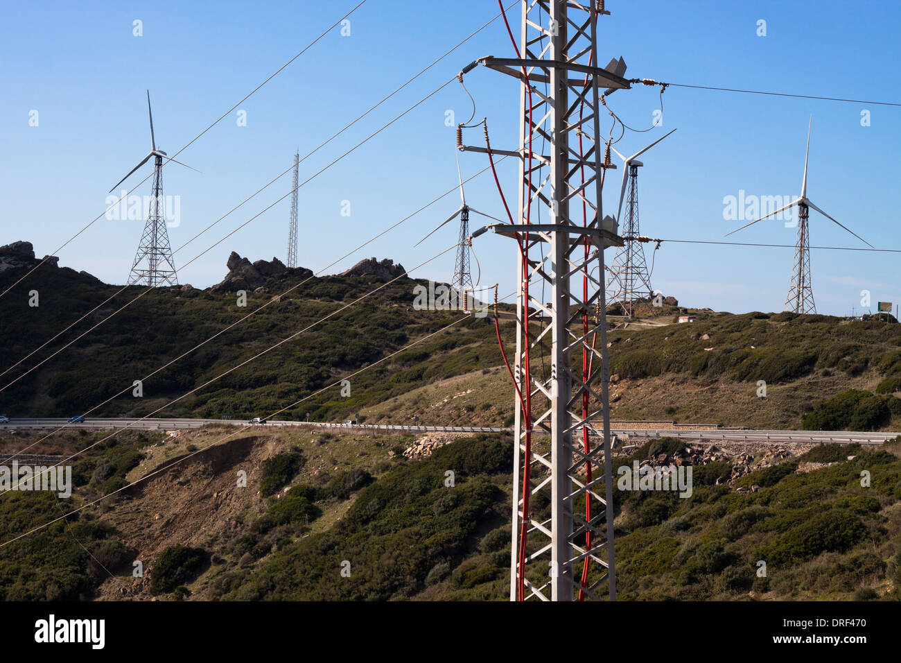 Green hills with electricity poles and wind turbines. Tarifa, Cadiz, Andalusia, Spain. Stock Photo