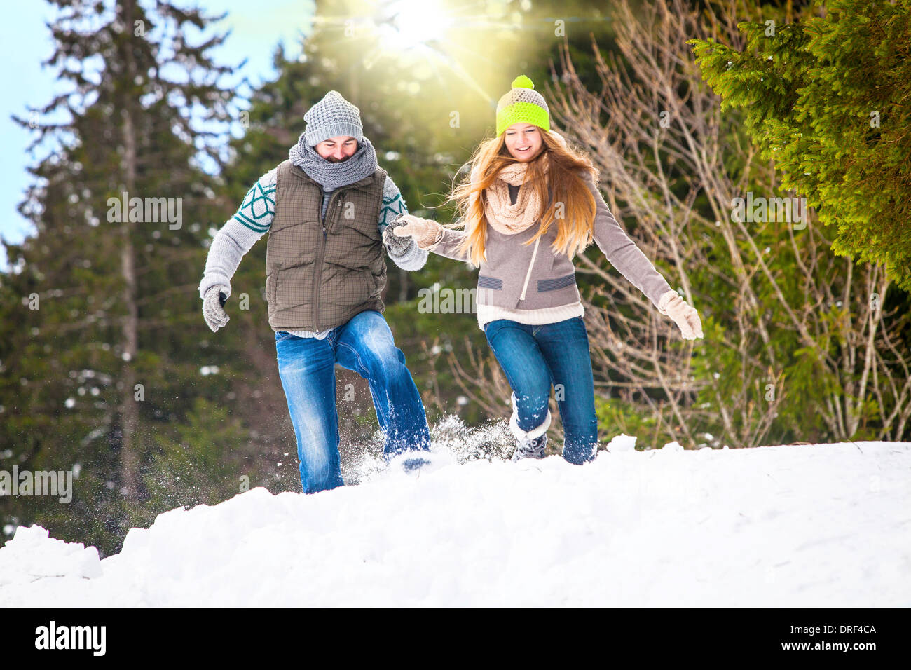 Couple Running In Snow, Spitzingsee, Bavaria, Germany Stock Photo