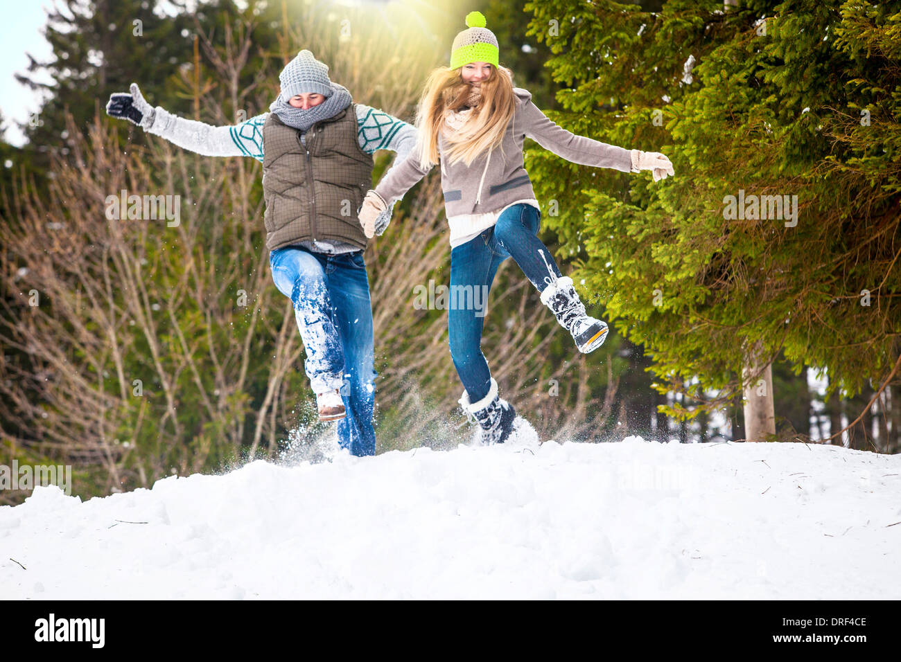 Couple Jumping In Snow, Spitzingsee, Bavaria, Germany Stock Photo