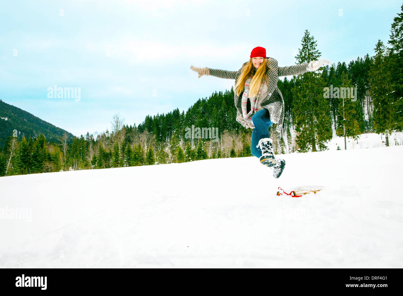 Woman Jumping In Snow, Spitzingsee, Germany Stock Photo