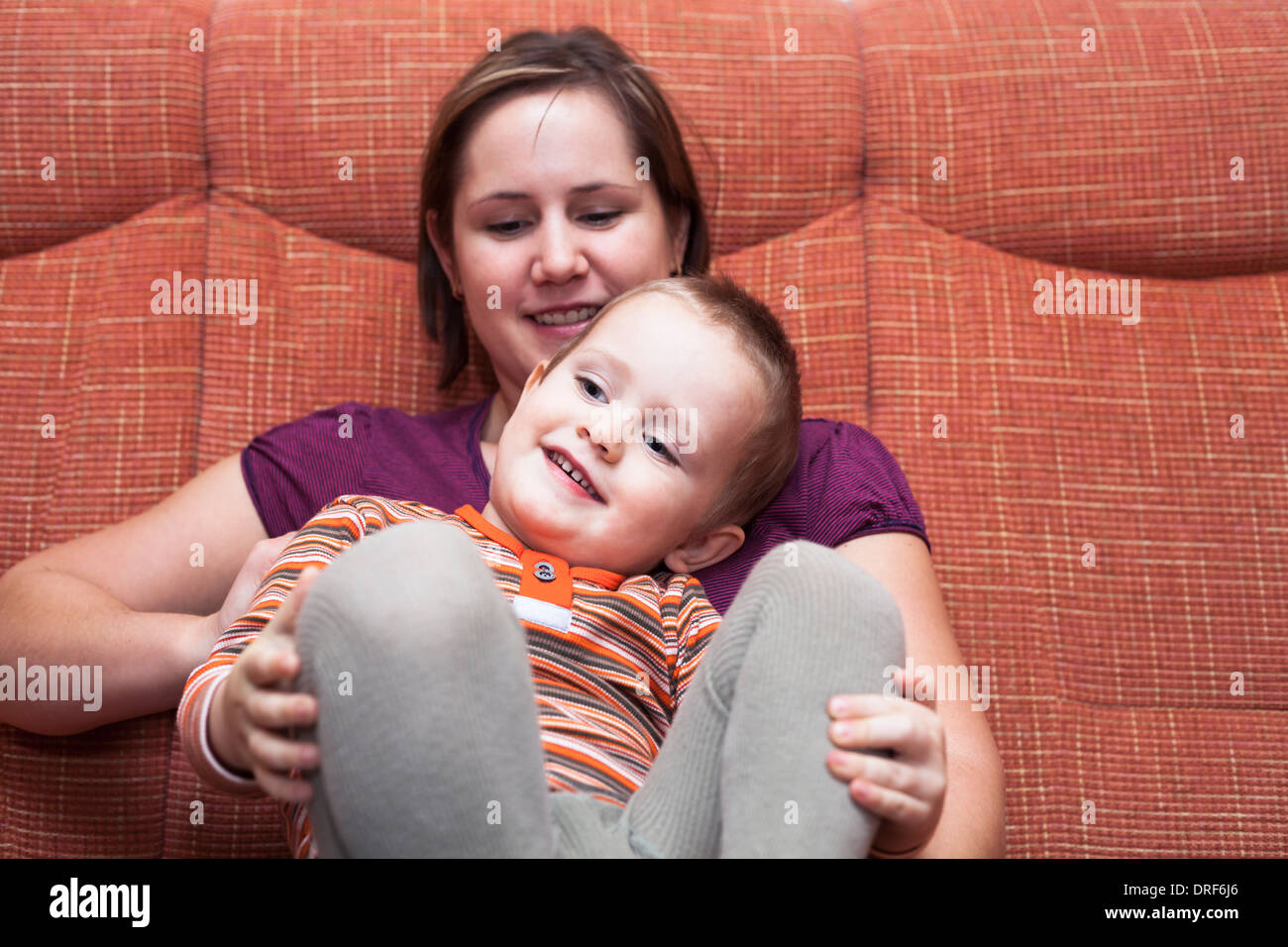 Happy child boy and mother on sofa Stock Photo