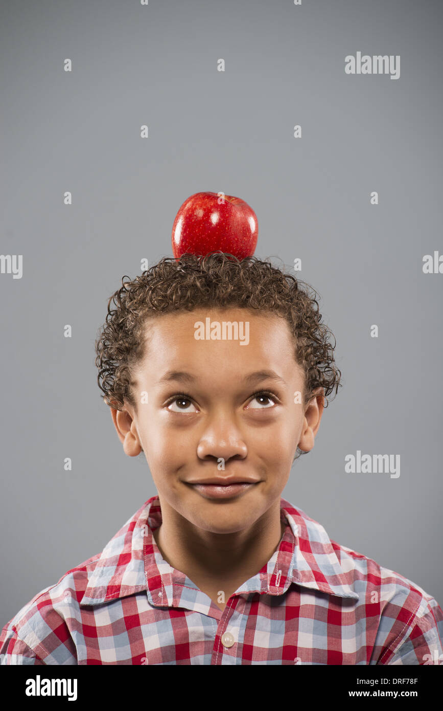 Utah USA boy concentrating still red apple balanced on head Stock Photo