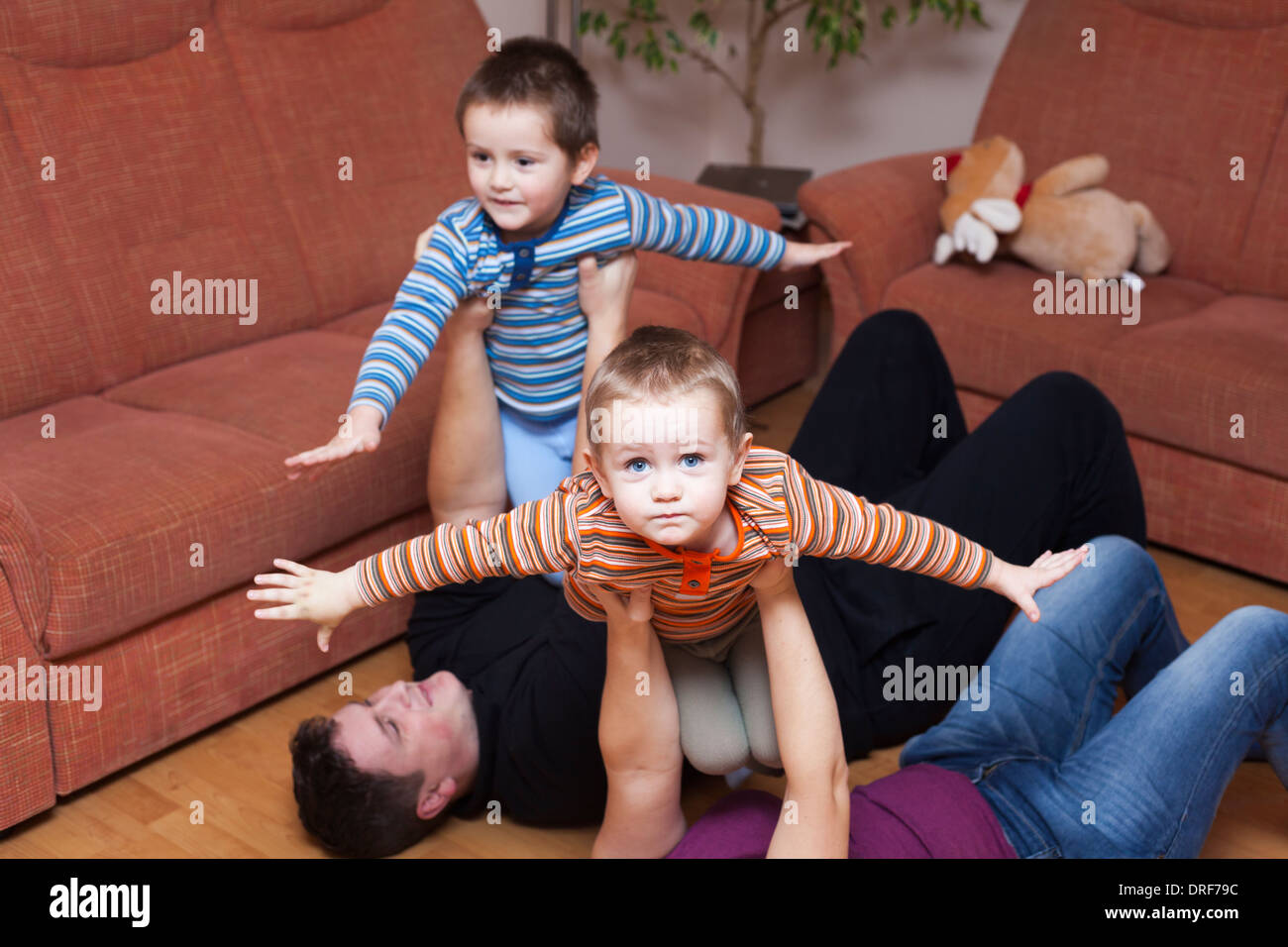 Happy parents playing with children at home Stock Photo