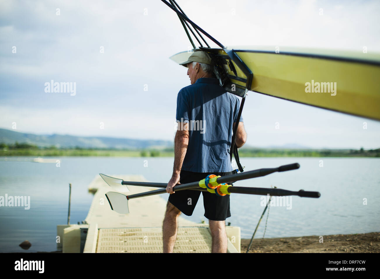 Colorado USA middle-aged man carrying oars and rowing shell Stock Photo