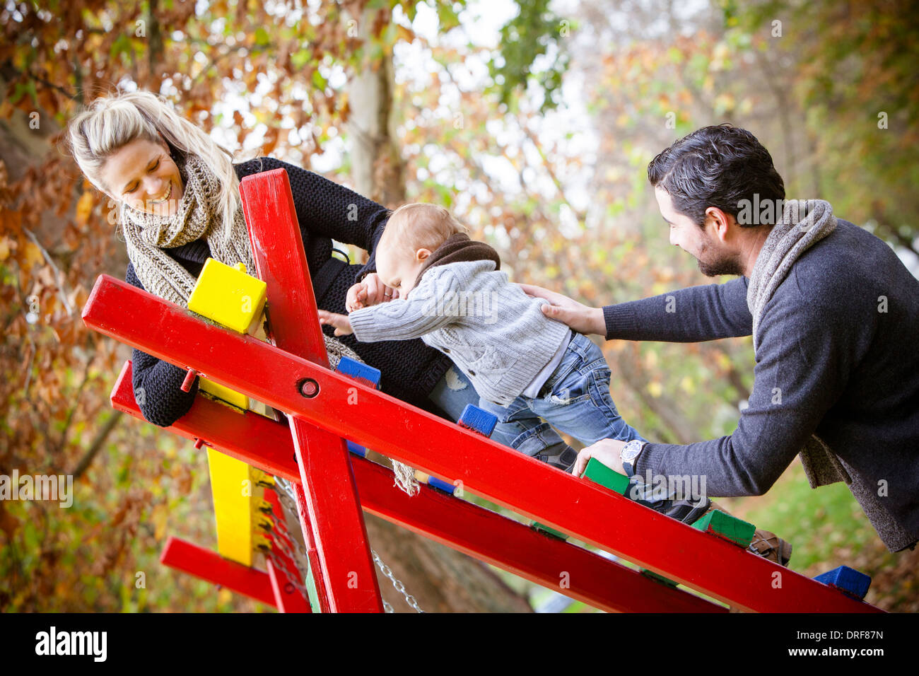 Parents together with son playing on jungle gym, Osijek, Croatia Stock Photo