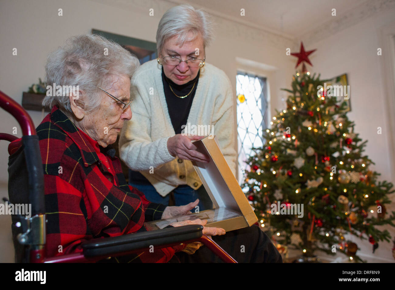 Detroit, Michigan - Dorothy Newell, 99, opens a Christmas present with the help of her daughter, Susan Newell, 65. Stock Photo