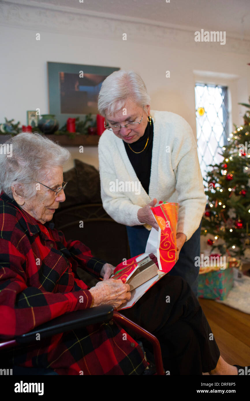 Couple Elderly Female Friends Wearing Face Mask Giving Christmas Present  Stock Photo by ©BasilicoStudioStock 430210076