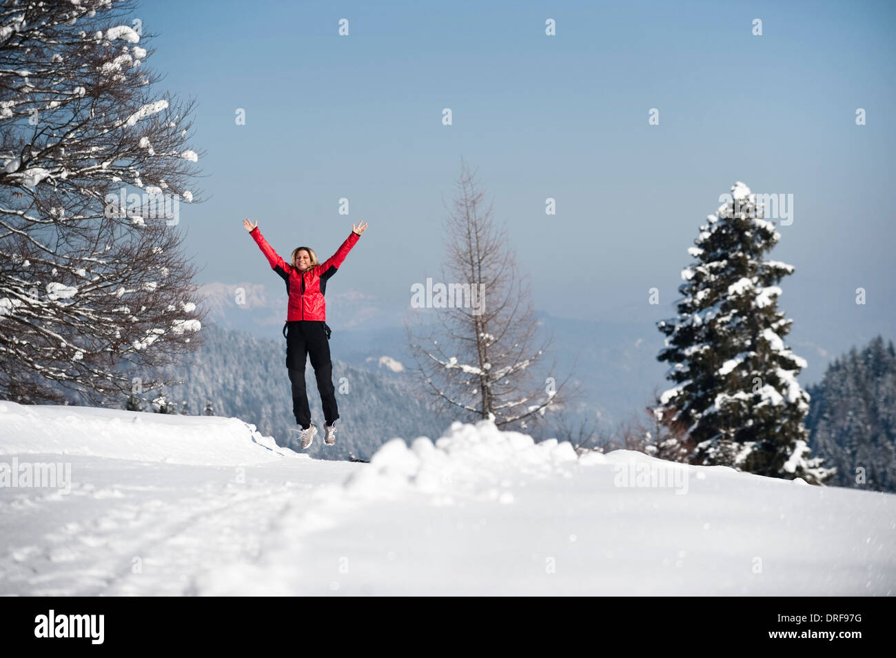 Woman jumping in winter landscape, Garmisch, Bavaria, Germany Stock Photo