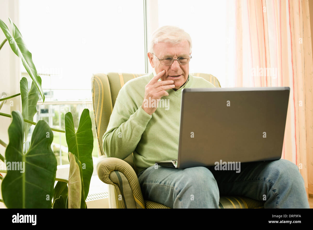 Senior man using laptop in nursing home, Bavaria, Germany Stock Photo