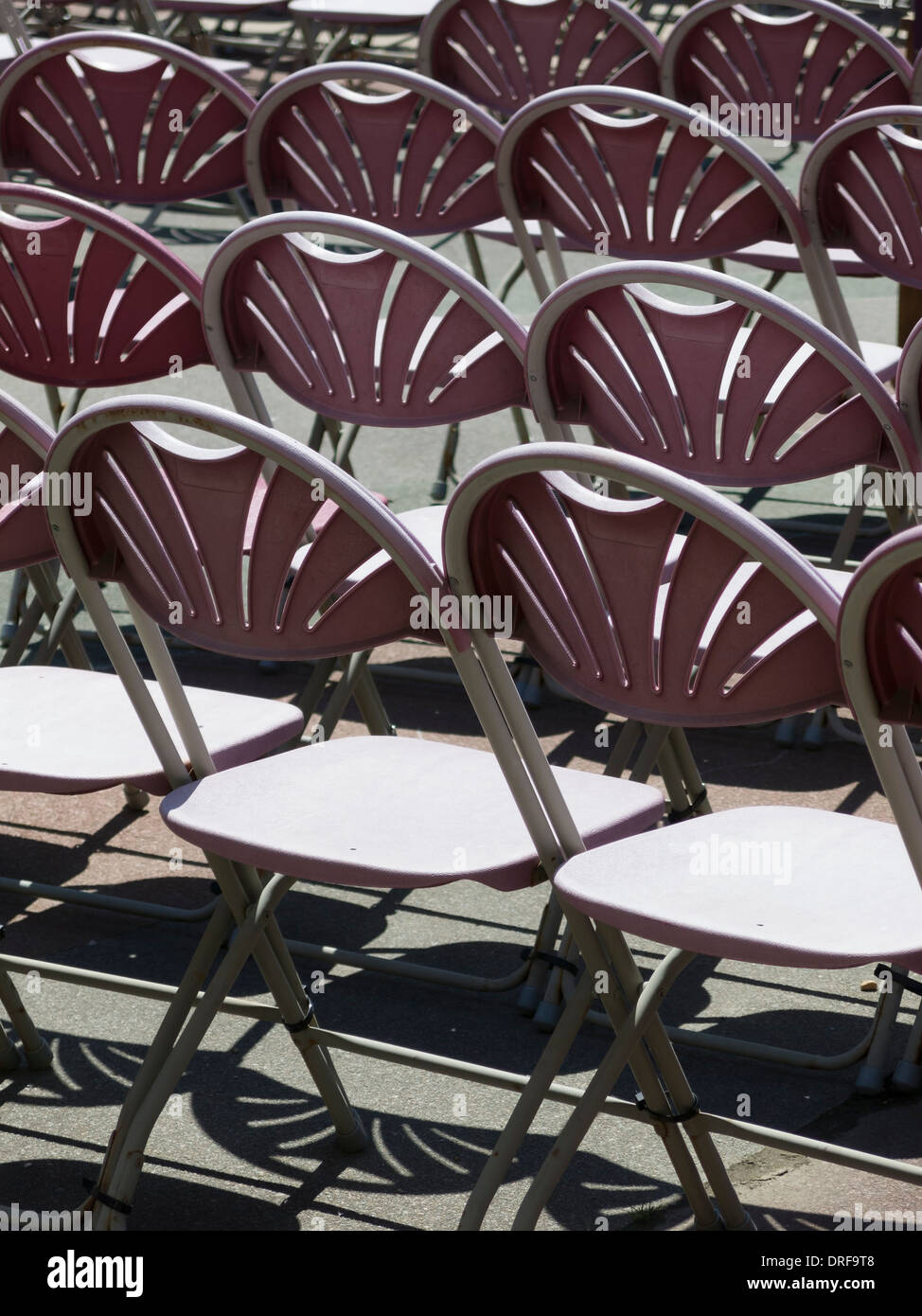 Rows of empty sunlit seats / chairs at Eastbourne Bandstand, Eastbourne, East Sussex, England, UK Stock Photo