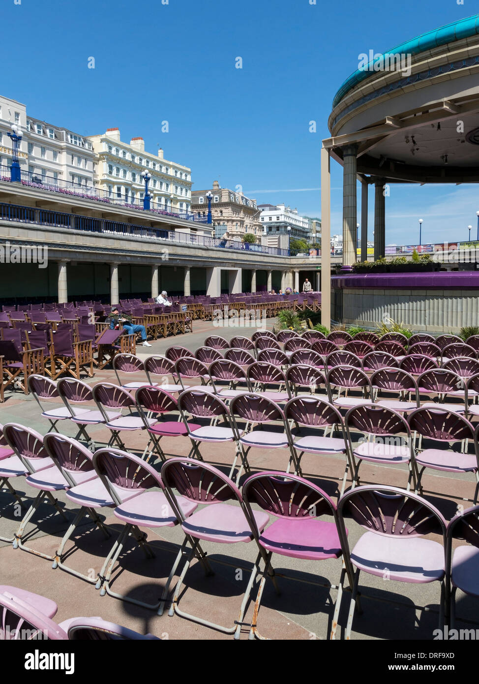 Rows of empty sunlit seats / chairs at Eastbourne Bandstand, Eastbourne, East Sussex, England, UK Stock Photo