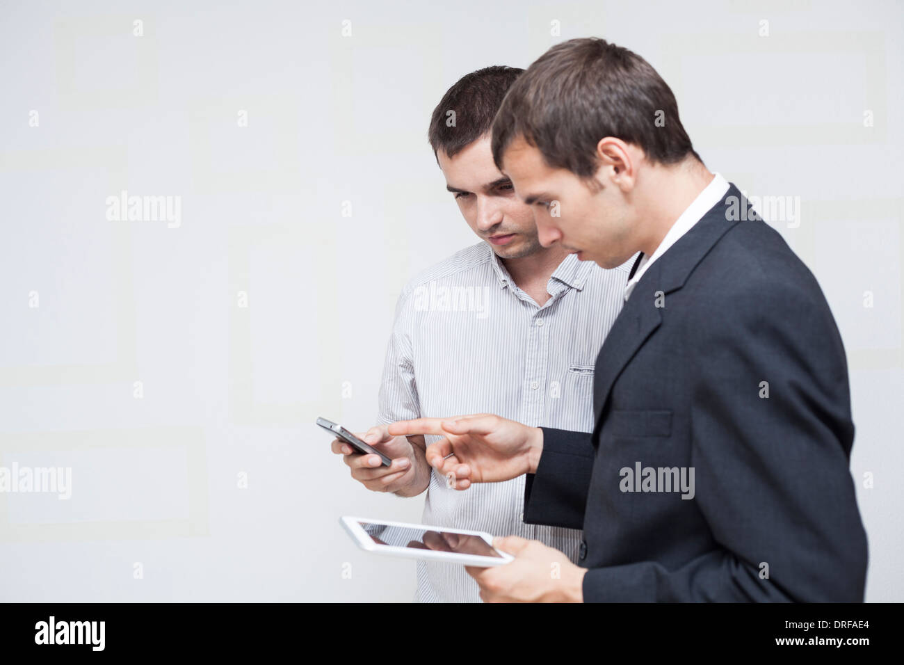 Two businessmen using digital tablet and smartphone. Stock Photo