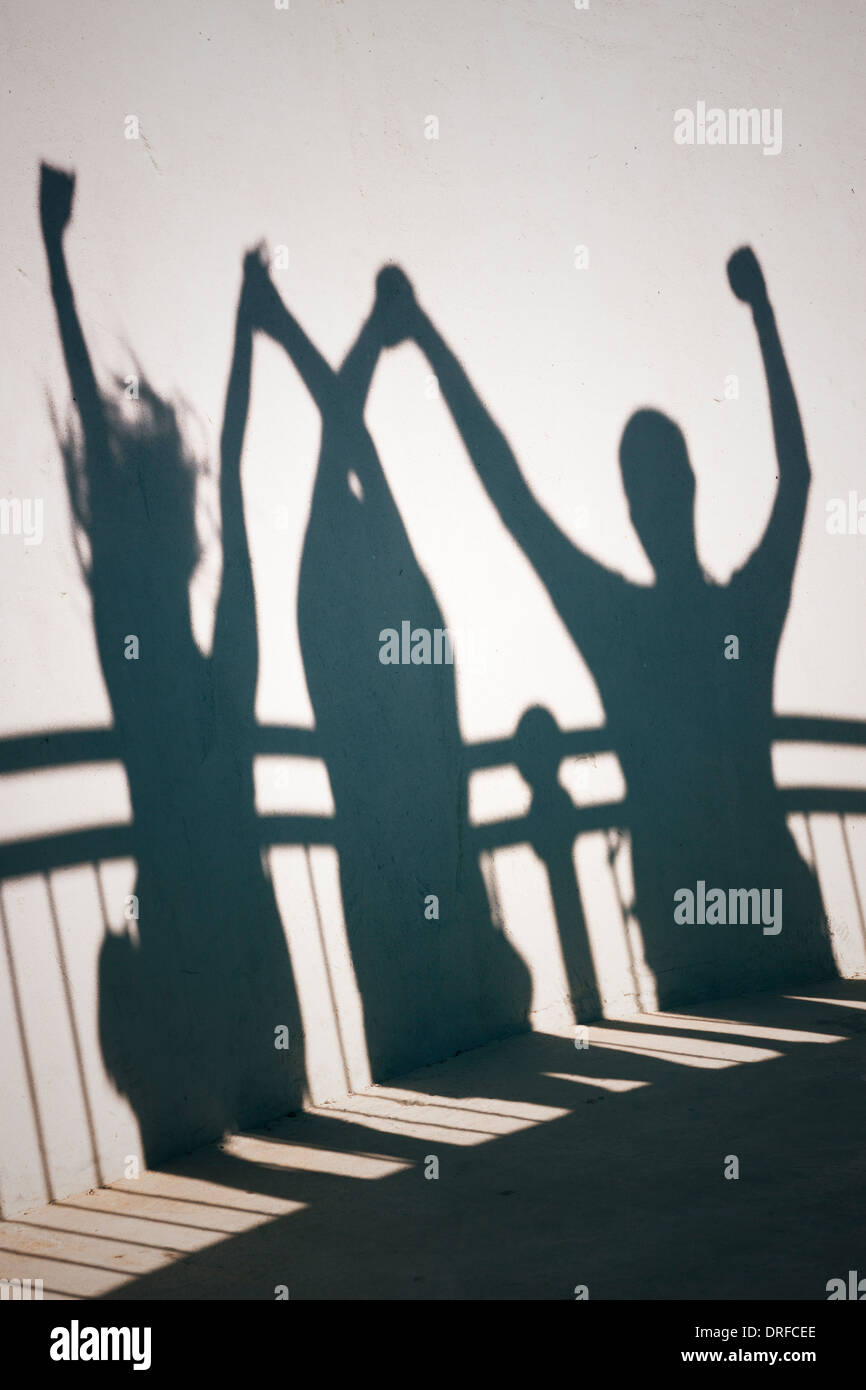 Creative photo of happy people shadows on white wall holding hands Stock Photo Alamy