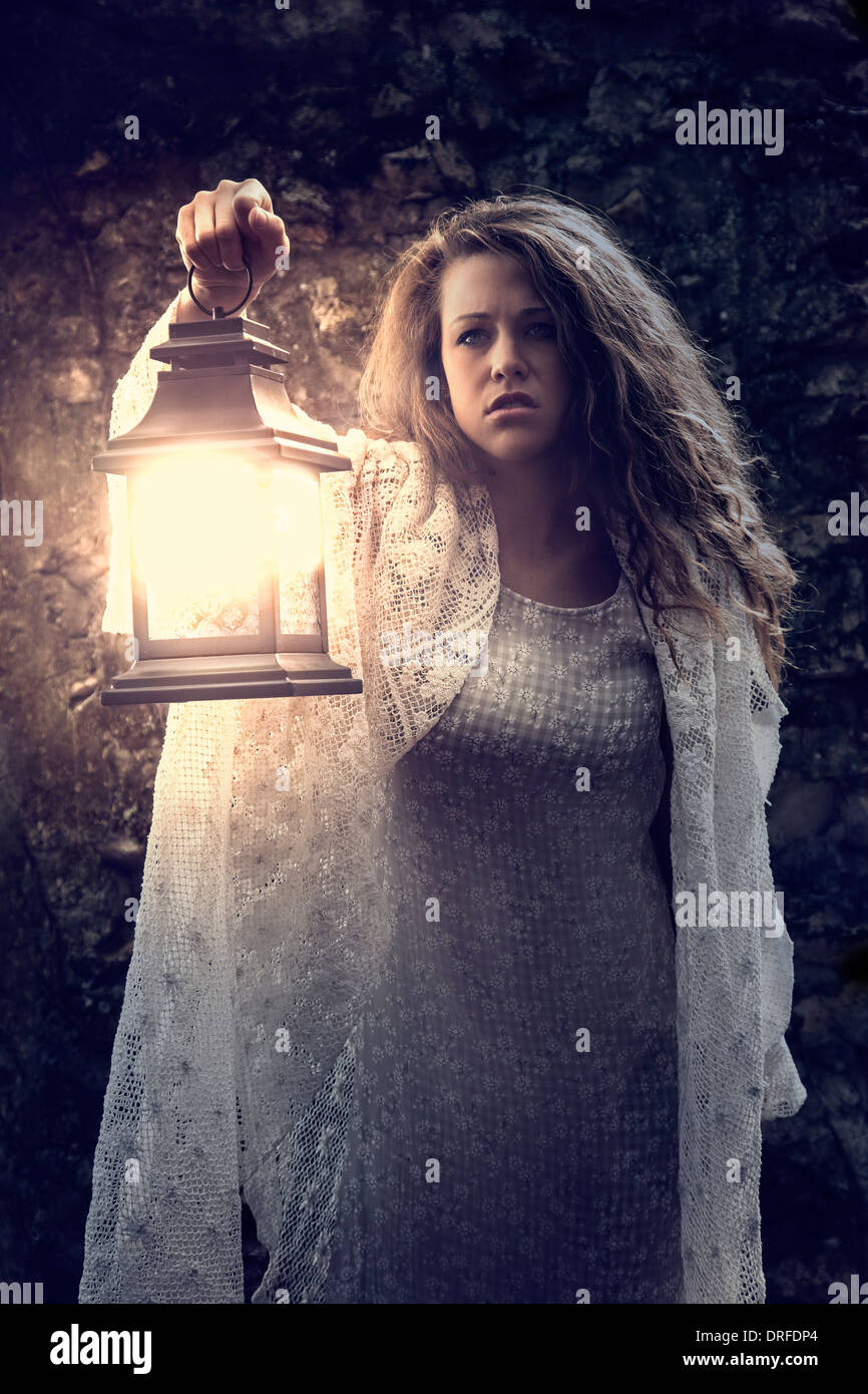 Woman holding lantern in the dark Stock Photo