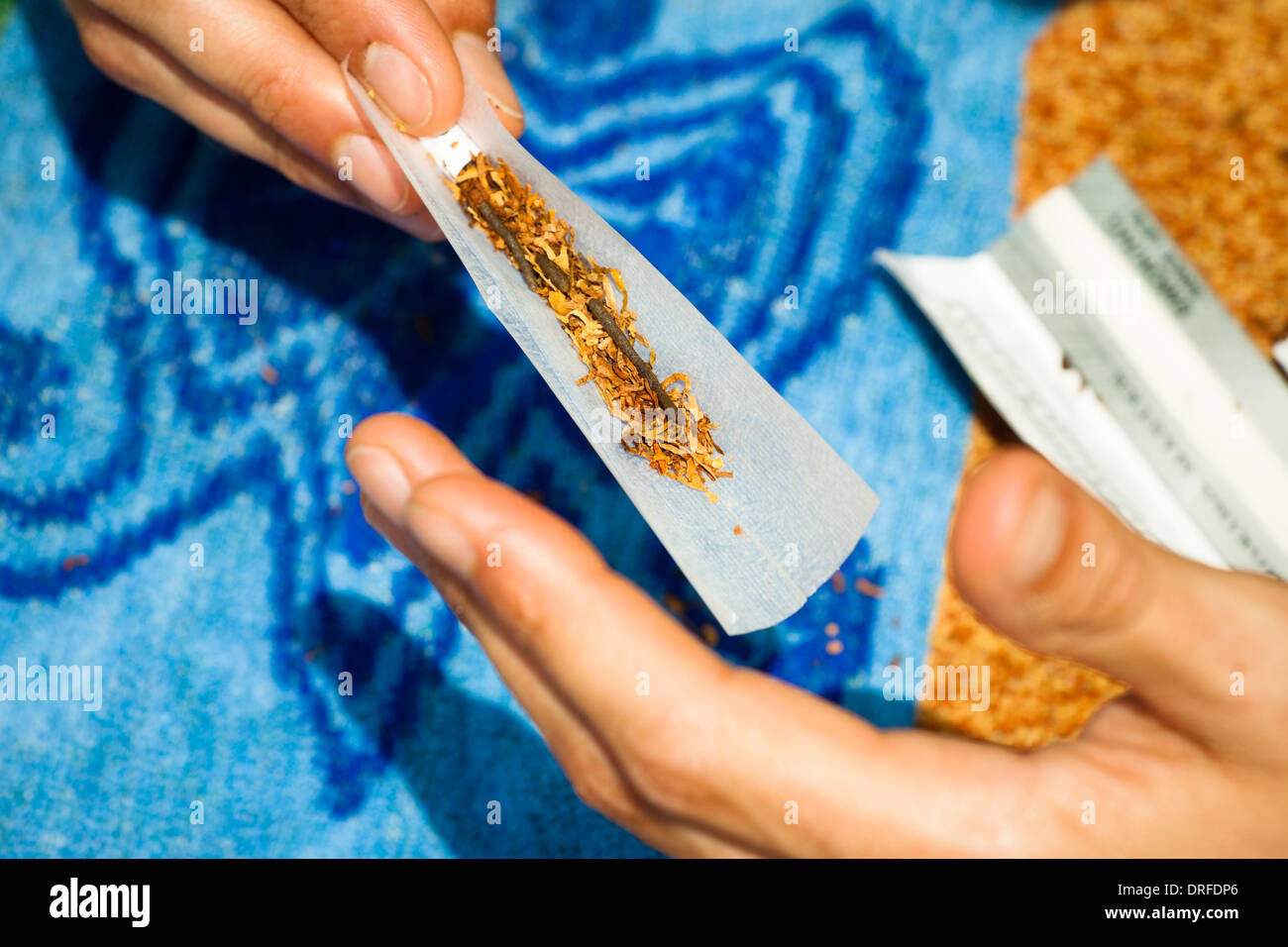 Close up of male hand rolling hashish joint. Stock Photo