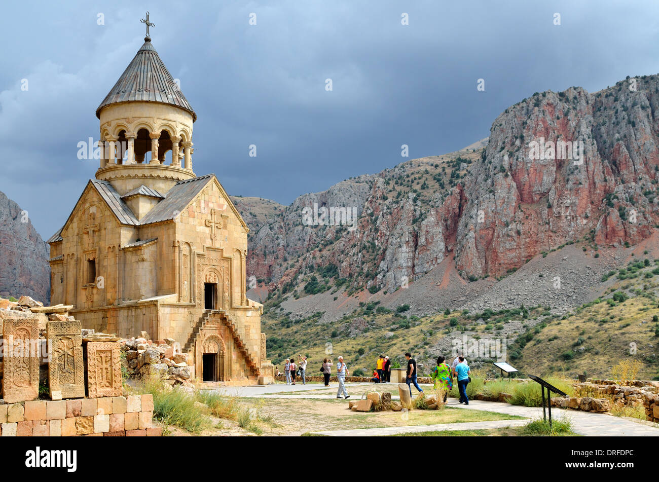 Khachkars and Surp Astvatsatsin, the Holy Mother of God church, with red cliffs in the background, Noravank monastery, Armenia Stock Photo