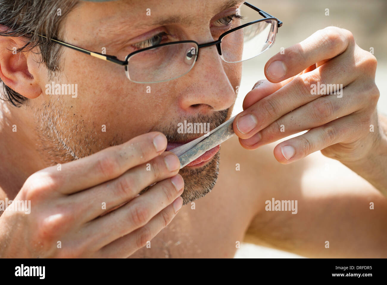 Close up of man rolling hashish joint. Stock Photo