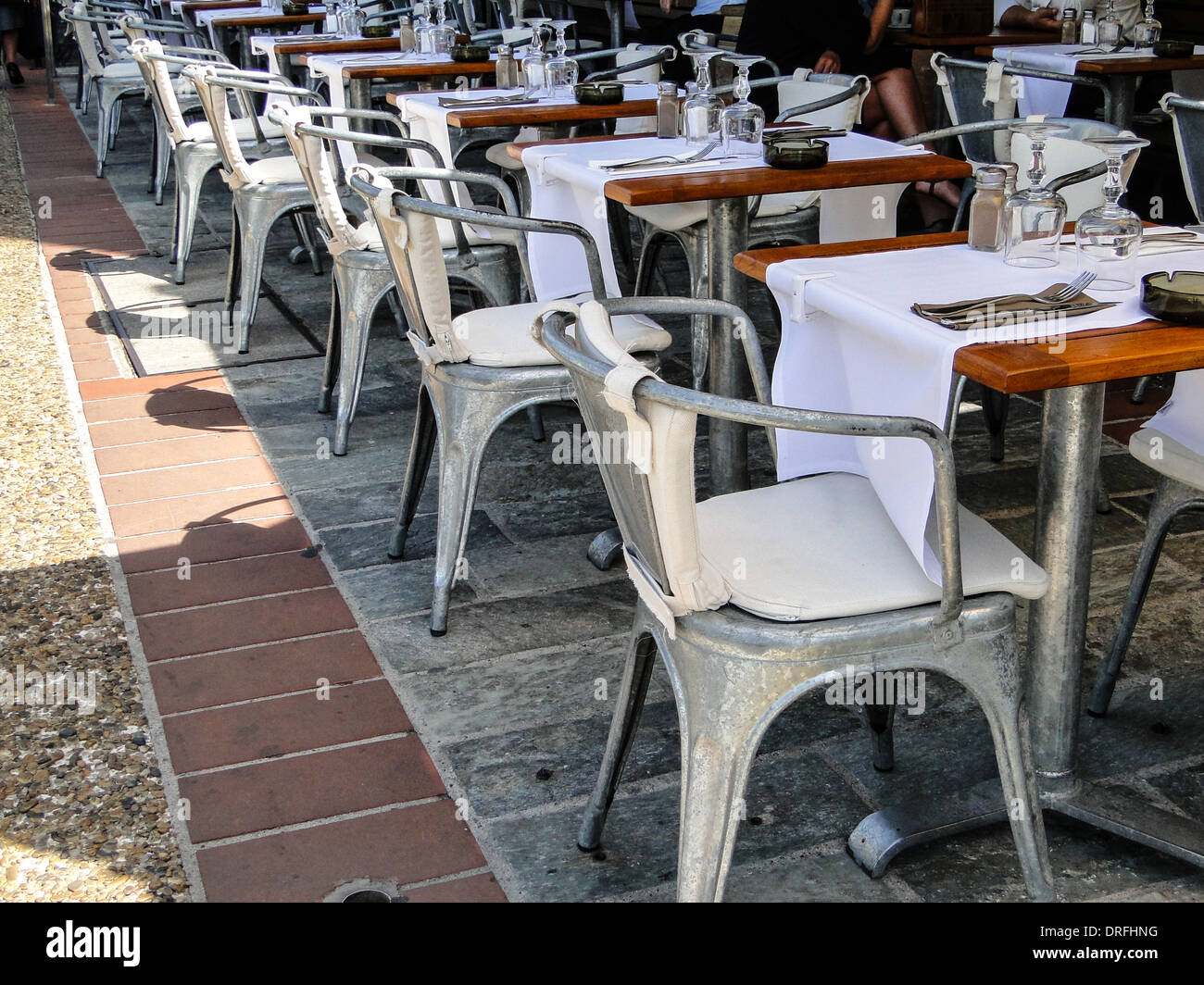 row of chairs and tables made of aluminium in a garden restaurant in