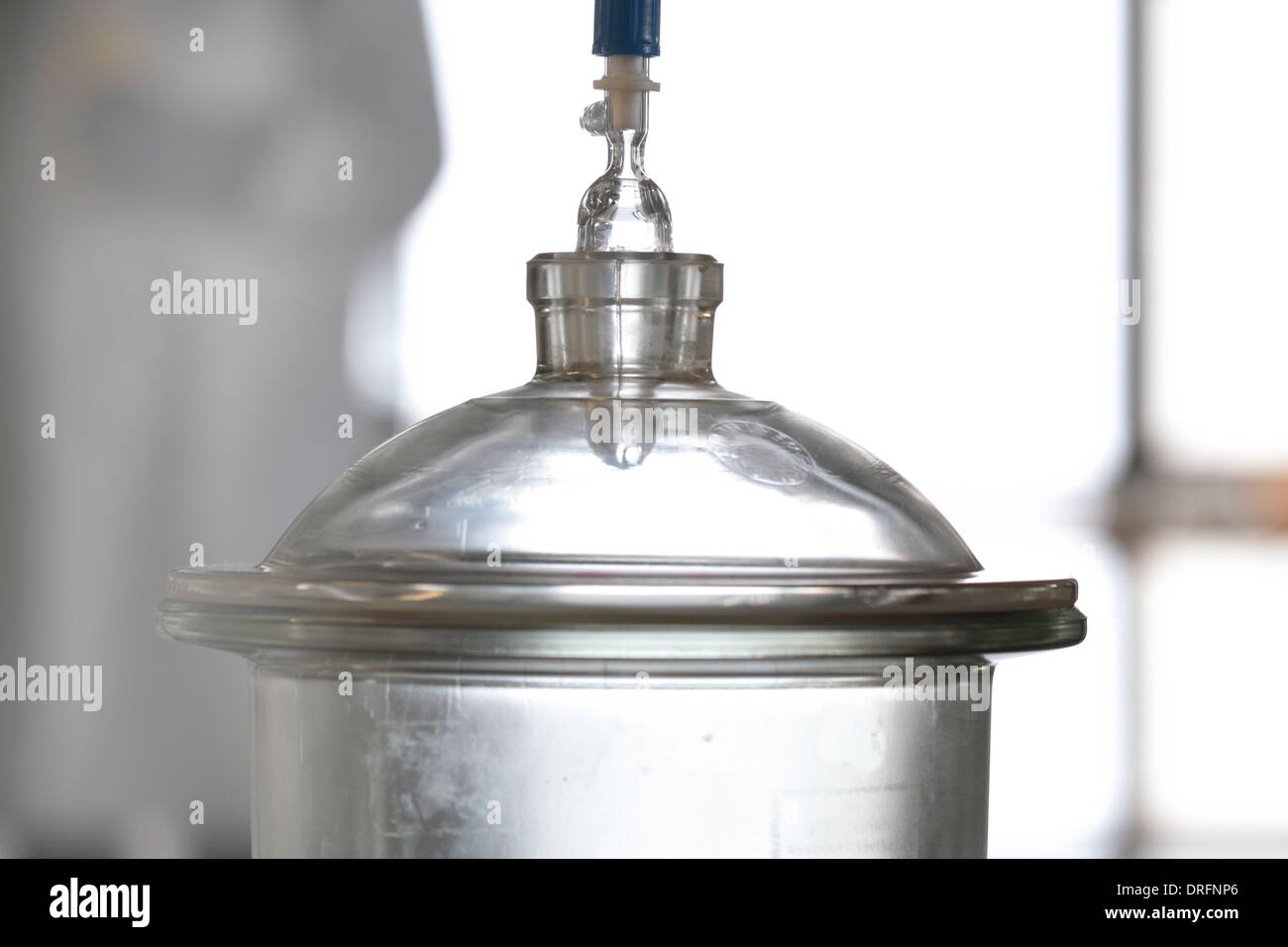 desiccator in a lab and technician standing in the background Stock