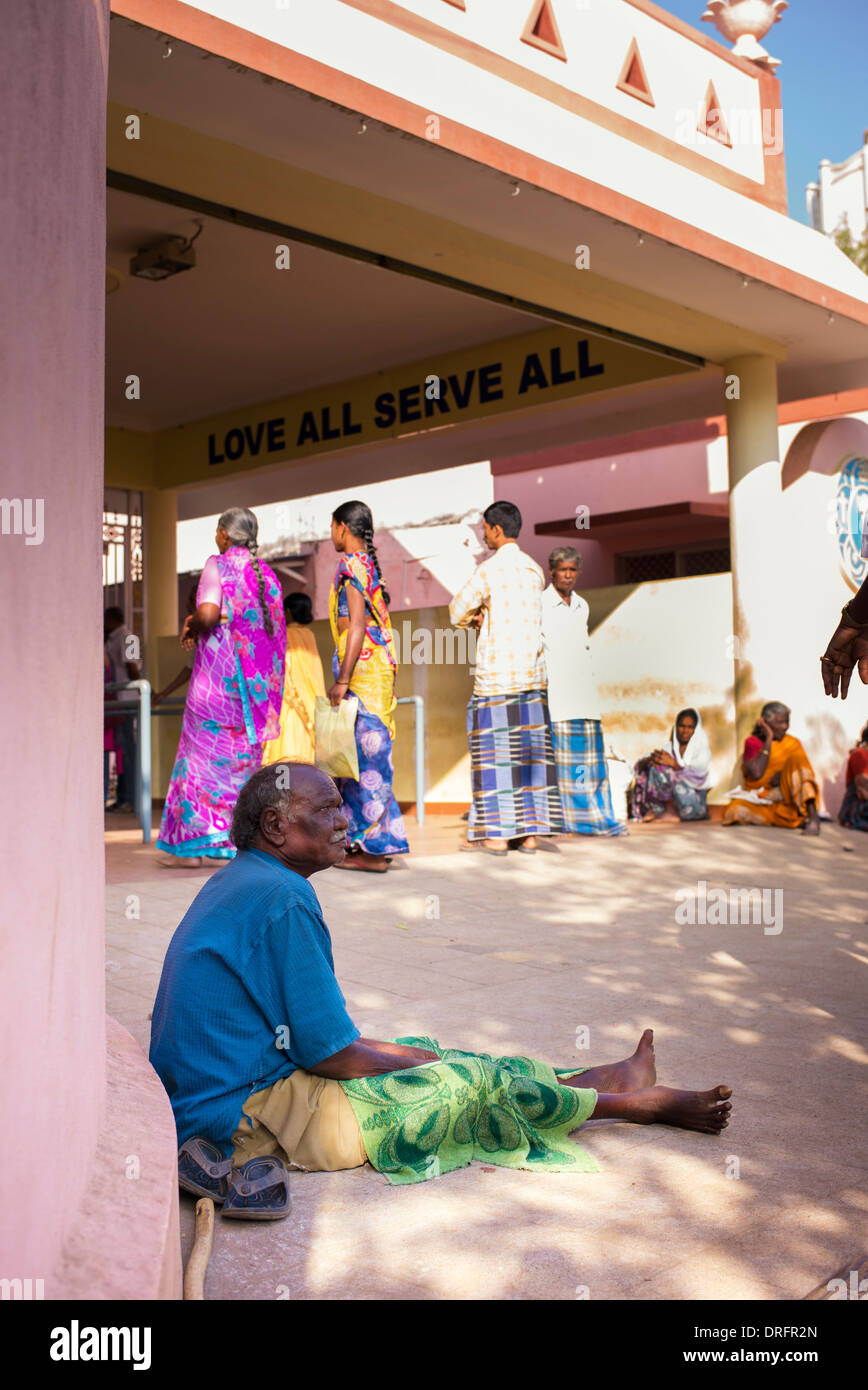 Old Indian man begging outside Sathya Sai Baba Super Speciality hospital. Puttaparthi, Andhra Pradesh, India Stock Photo