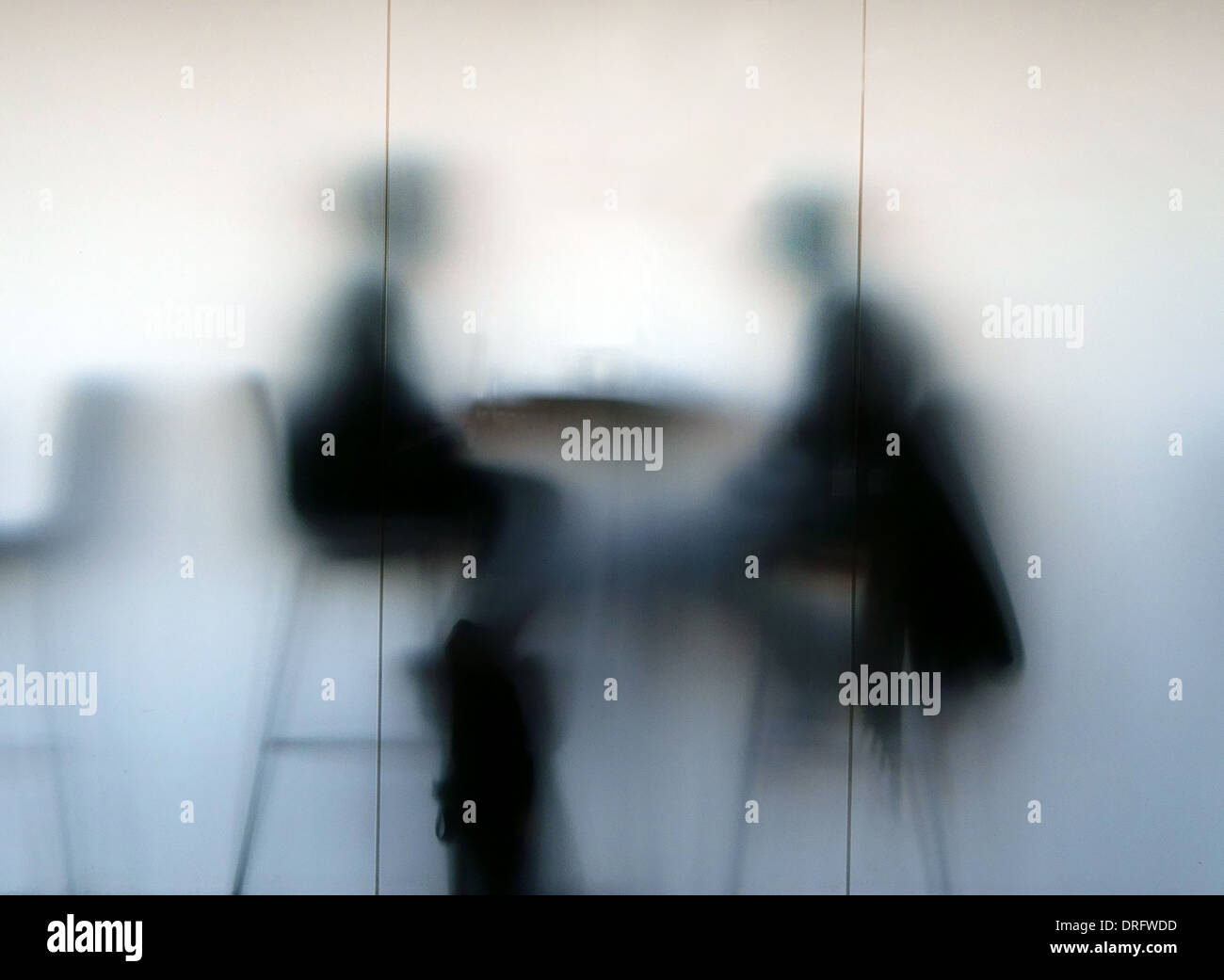People in cafe silhouetted behind frosted glass window, London Stock Photo
